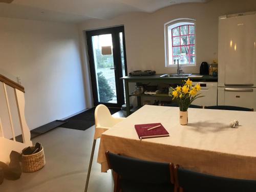 a kitchen with a table with yellow flowers on it at Hesselhogaard Bed & Breakfast in Grindsted