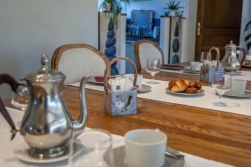- une table avec une bouilloire et un plateau de croissants dans l'établissement Clos du Mont Rouge, à Bouzy
