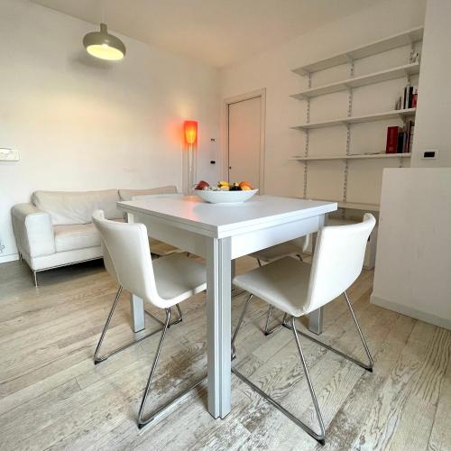 einen weißen Tisch und Stühle im Wohnzimmer in der Unterkunft Incantevole appartamento sul fiume 
