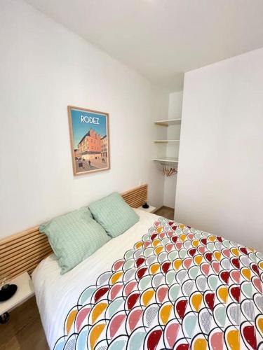 sypialnia z łóżkiem z kolorową kołdrą w obiekcie Hyper centre appartement Cosy WIFI w mieście Rodez