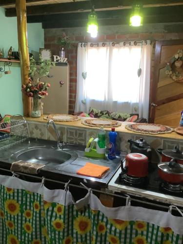 uma cozinha com um lavatório e um fogão forno superior em Pousada Taruma Challes 02 em Bonito