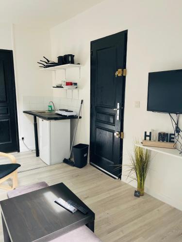 - un salon avec une porte noire et une table dans l'établissement petit appartement T2 à 5 min de la gare, à Bordeaux