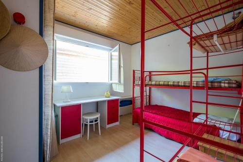 une chambre avec deux lits superposés et un bureau dans l'établissement La Villa Bleue, à Lège-Cap-Ferret