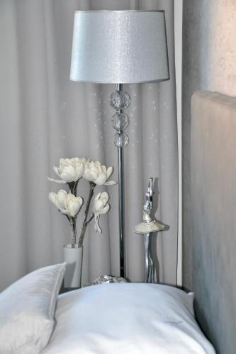 a lamp sitting next to a bed with white flowers at Apartmany u Polanských in Bulhary
