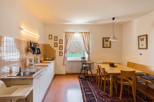 a kitchen and dining room with a table and chairs at Arzenhof, Baron Di Pauli in Caldaro