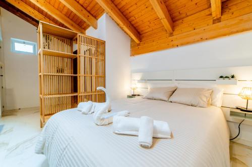 ein Schlafzimmer mit einem großen weißen Bett mit Handtüchern darauf in der Unterkunft Ático Santa Clara in Burgos