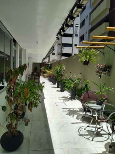 a patio with potted plants and a table and chairs at One Hotel in João Pessoa