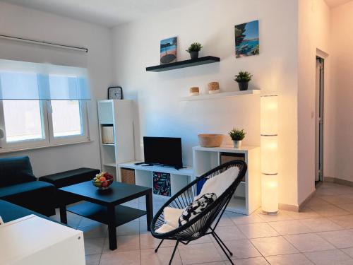 a living room with a couch and a chair at Sea View Apartments in Grebaštica