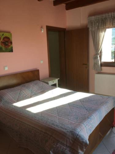ein Schlafzimmer mit einem Bett in einem Zimmer mit Fenster in der Unterkunft Eva's cottage Kastelli Pediados in Kardhoulianós