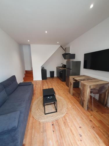 a living room with a blue couch and a table at Appartement chic et cosy in Authézat
