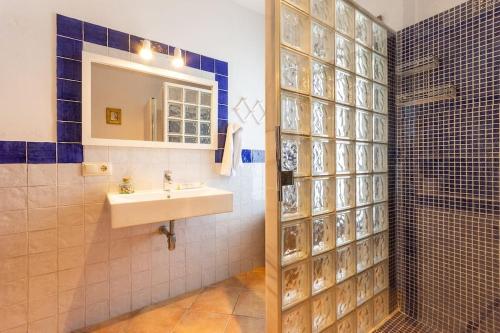 een badkamer met een wastafel en een douche met een spiegel bij Sa ROTA in Santa Margarita