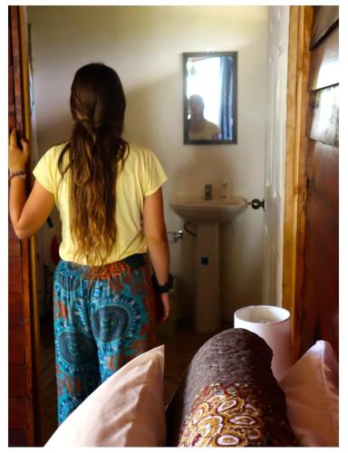 a woman standing in a bedroom looking in a mirror at Terrazas del Golfo in La Palma