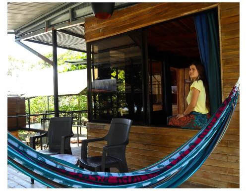 a woman sitting in a hammock outside of a house at Terrazas del Golfo in La Palma