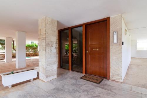 a hallway with a wooden door and a stone pillar at Sun & Sea Suite, Kavouri in Athens