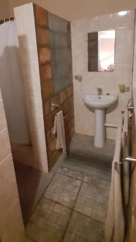 a bathroom with a sink and a toilet and a shower at Venha Juntos Guest Homes in Miramar