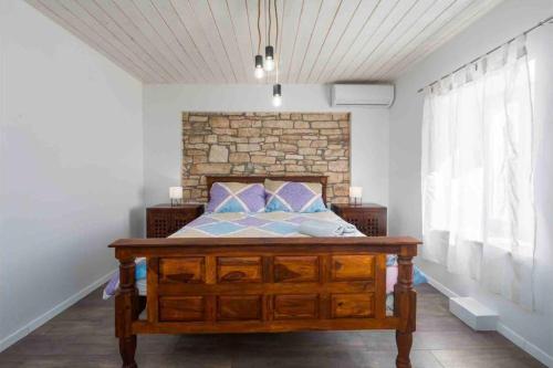 a bedroom with a bed and a brick wall at Villa Rosa Kringa in Tinjan