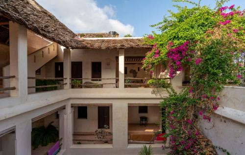拉穆的住宿－Amma's House，享有粉红色花卉建筑的外部景色