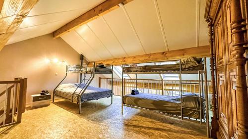 2 stapelbedden in een kamer met een dak bij Au chant du coq in Wancennes