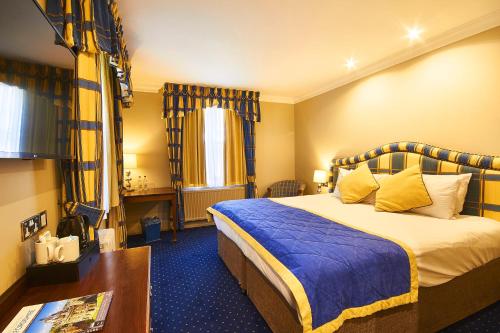 una habitación de hotel con una cama grande y una mesa en The George Hotel, en Wallingford