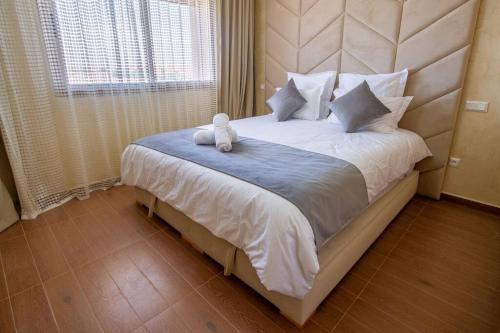 een bed met een knuffeldier erop bij Appartement luxueux Coralia avec piscine in Marrakesh