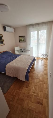 1 dormitorio con 1 cama y suelo de madera en Slavonija, en Slavonski Brod