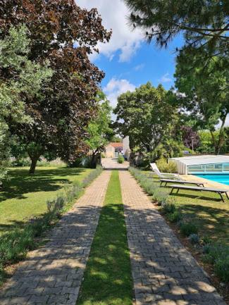 un camino empedrado en un parque con piscina en Gîte tout confort (SPA, Sauna, piscine chauffée), en Saint-Vivien