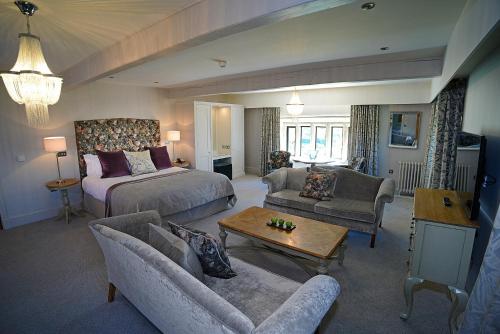 a living room with a bed and a living room with a couch at Stanley House Hotel & Spa in Blackburn
