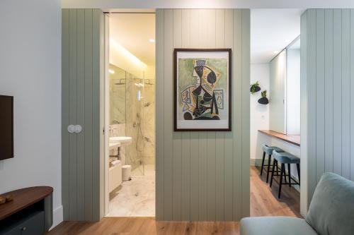 a bathroom with a painting on the wall at ORM Portas Santa Catarina Apartments in Porto