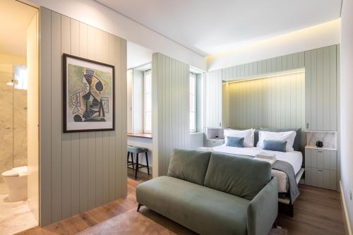 波多的住宿－ORM Portas Santa Catarina Apartments，一间卧室配有一张床、一张沙发和一把椅子