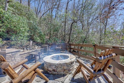 a patio with a fire pit and two wooden chairs at Beautiful Bryson City Home with Hot Tub and Mtn Views! in Bryson City
