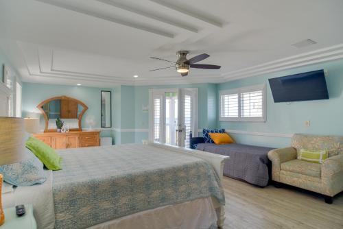 um quarto com uma cama, um sofá e uma televisão em Breezy White Sands House Steps to Gulf Shore! em Clearwater Beach