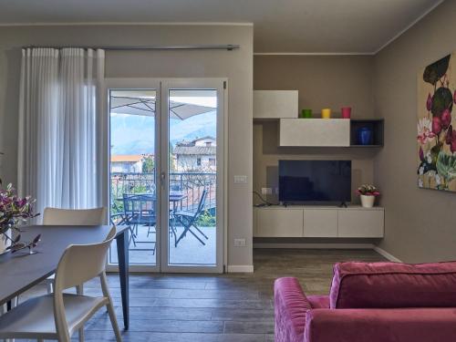 uma sala de estar com um sofá e uma mesa com uma televisão em Apartment Cà Ben-2 by Interhome em Dongo