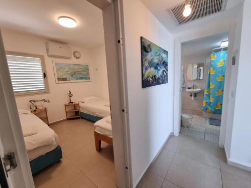a room with two beds and a bathroom at Albi Boutique Apartments in ‘Akko