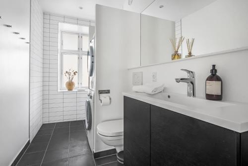 NABO Hotel Apartments في كوبنهاغن: حمام ابيض مع مرحاض ومغسلة