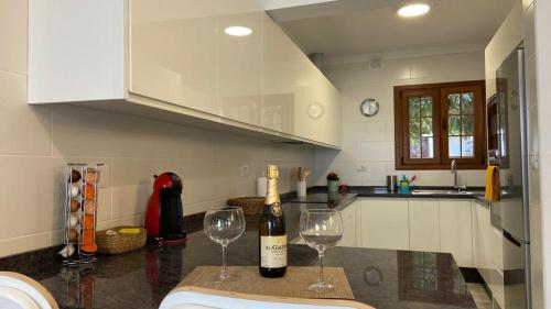 a kitchen with a bottle of wine and two wine glasses at Casa Pepa y Argeo in Mazo