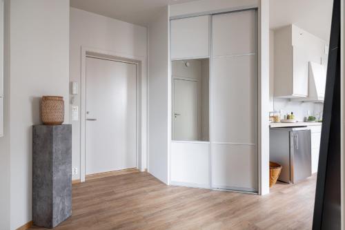 a white kitchen with white cabinets and a wooden floor at Hotel suite apartment in Oslo