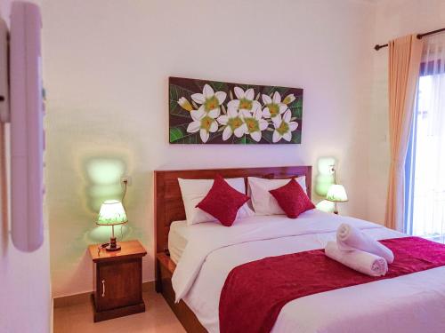 a bedroom with two beds with red pillows at Juan Beach Bungalow in Nusa Penida