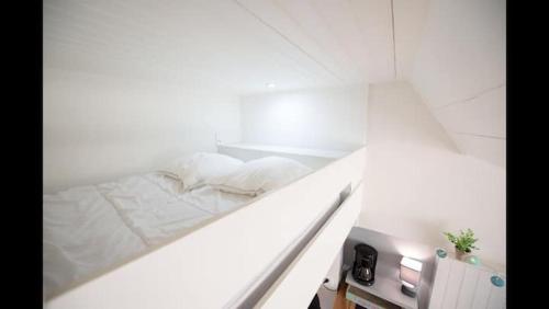 a white room with a bed on a counter at L Appart’ Grande Plage in Les Sables-d'Olonne