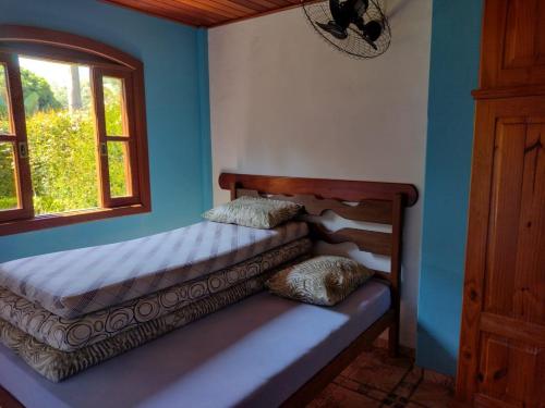 two beds in a room with a window at Casa Temporada em Lumiar in Lumiar