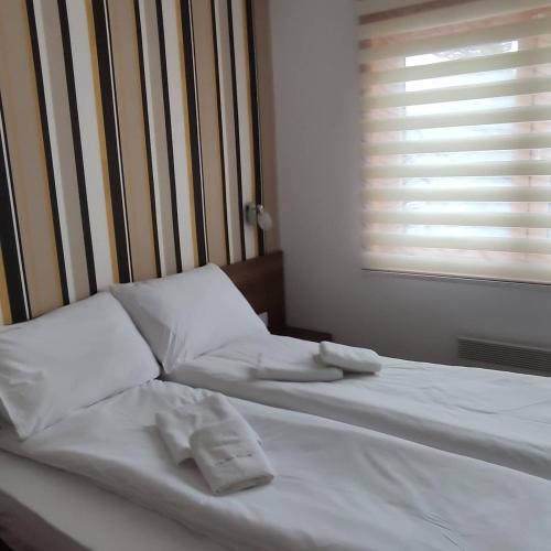 a bed with two white pillows and a window at Vila Pino Silvestre in Zlatibor