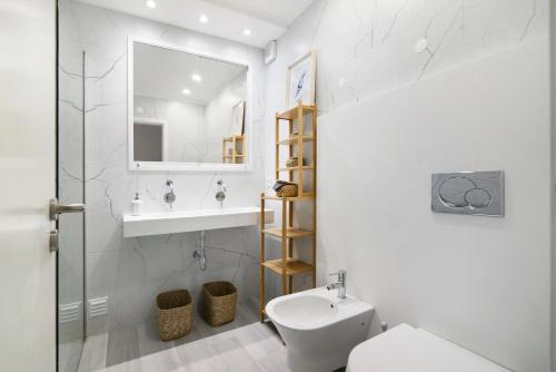a bathroom with a sink and a toilet and a mirror at Apartamento Acácia in Vale do Lobo