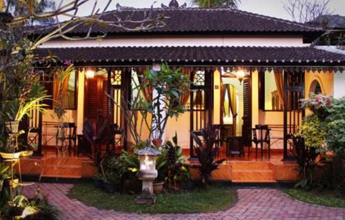 a house with a porch with a table and chairs at Guru Ratna in Munduk
