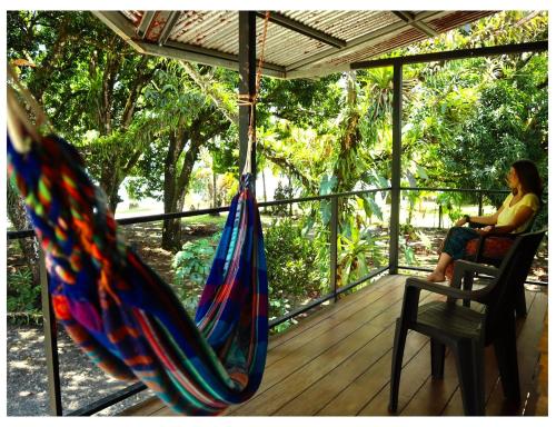 a woman sitting on a porch with a hammock at Terrazas del Golfo in La Palma