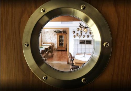 a mirror hanging on a wall with a living room at Gasthof zum Schiff in Obereisenheim