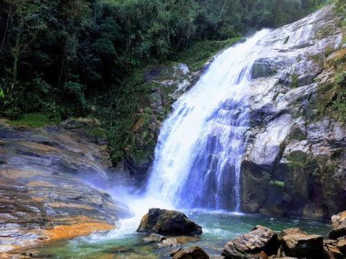a waterfall in the middle of a river at Linda casa de condomínio em Boiçucanga in São Sebastião