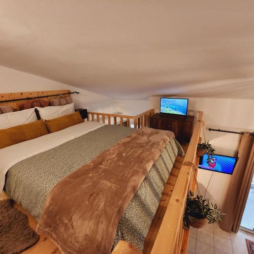 a bedroom with a bed and a flat screen tv at Luxury Loft Apartment Vivian in Patra
