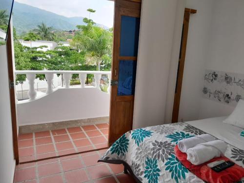 um quarto com uma cama e vista para uma varanda em Hotel Santa Fe del Parque em Santa Fe de Antioquia