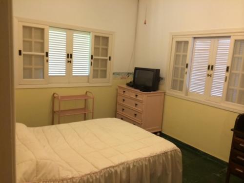 sypialnia z łóżkiem i telewizorem na komodzie w obiekcie Costa Verde Tabatinga, Caraguatatuba w mieście Caraguatatuba