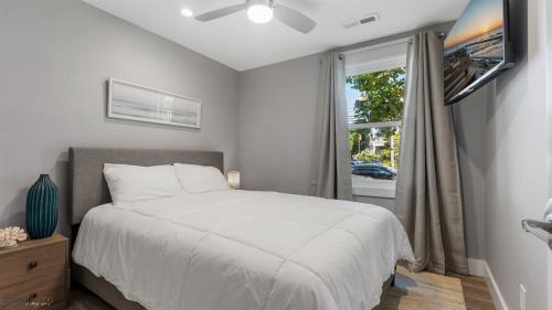 a bedroom with a white bed and a window at Newly Renovated 3 Bedroom With High-end Finishes Only 2 Blocks From The Beach! in Wildwood