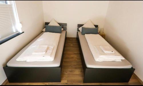 2 camas en una habitación pequeña en un dormitorio en B&B Malú am Ring, en Müllenbach